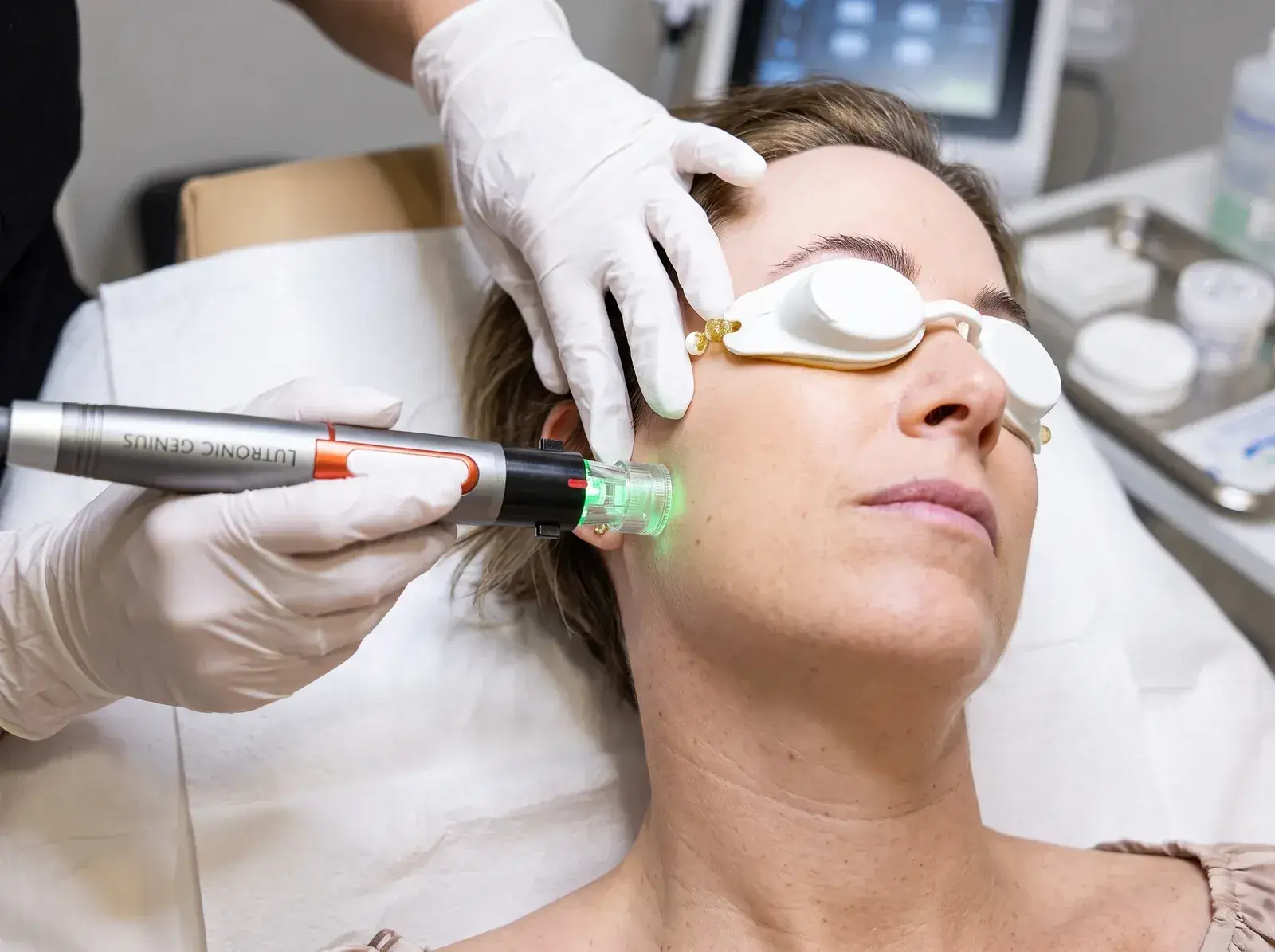 A Well Labs+ provider performing a Genius RF microneedling treatment on a client's face