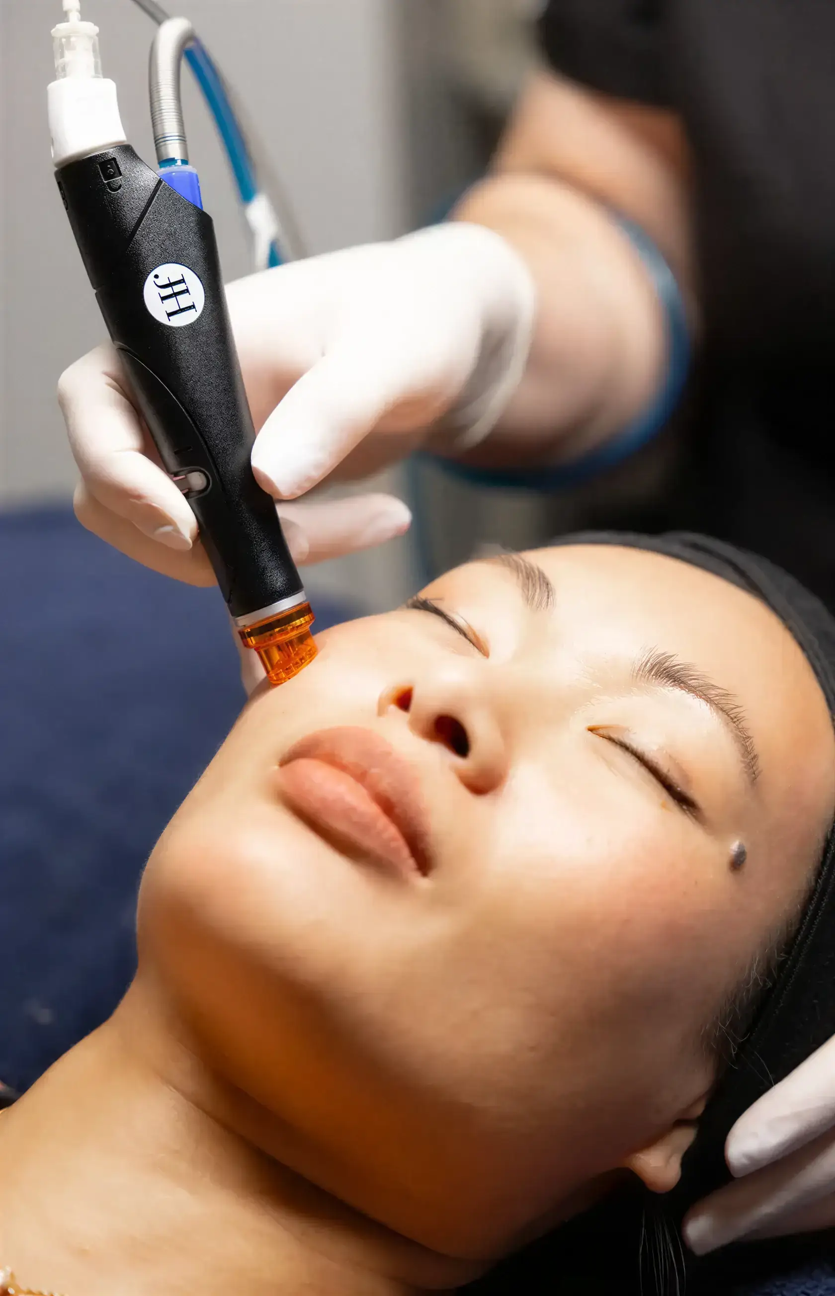 A Well Labs+ provider performing a Glo2Facial oxygen treatment on a client's face
