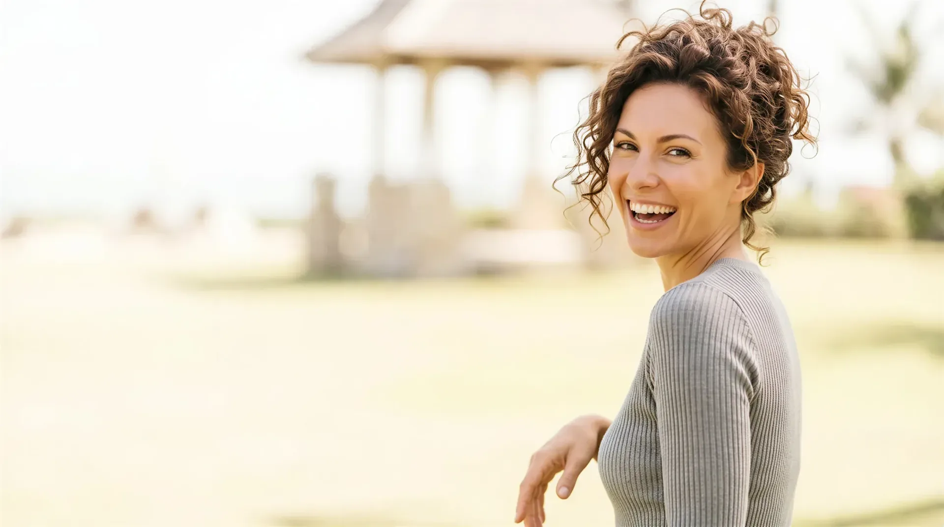 Smiling woman with smooth, renewed-looking skin outdoors in warm light, evoking the skin-texture support of Ariessence PDGF in Dallas