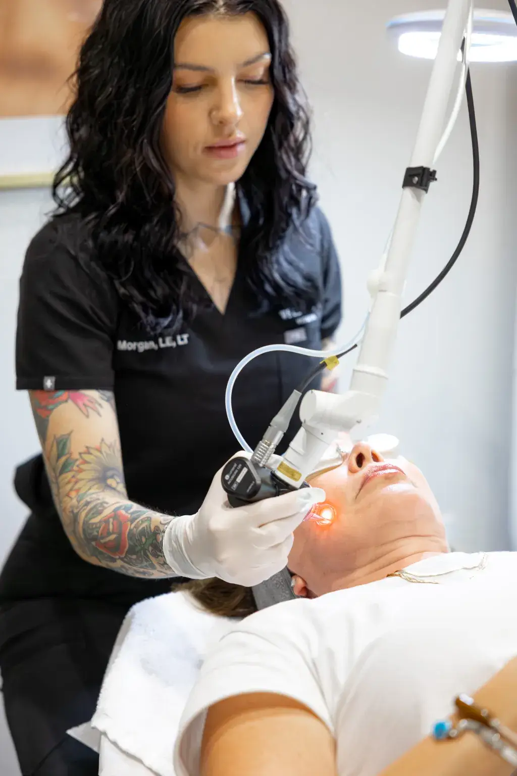 A Well Labs+ provider guiding the Hollywood Spectra laser handpiece during an in-office laser session