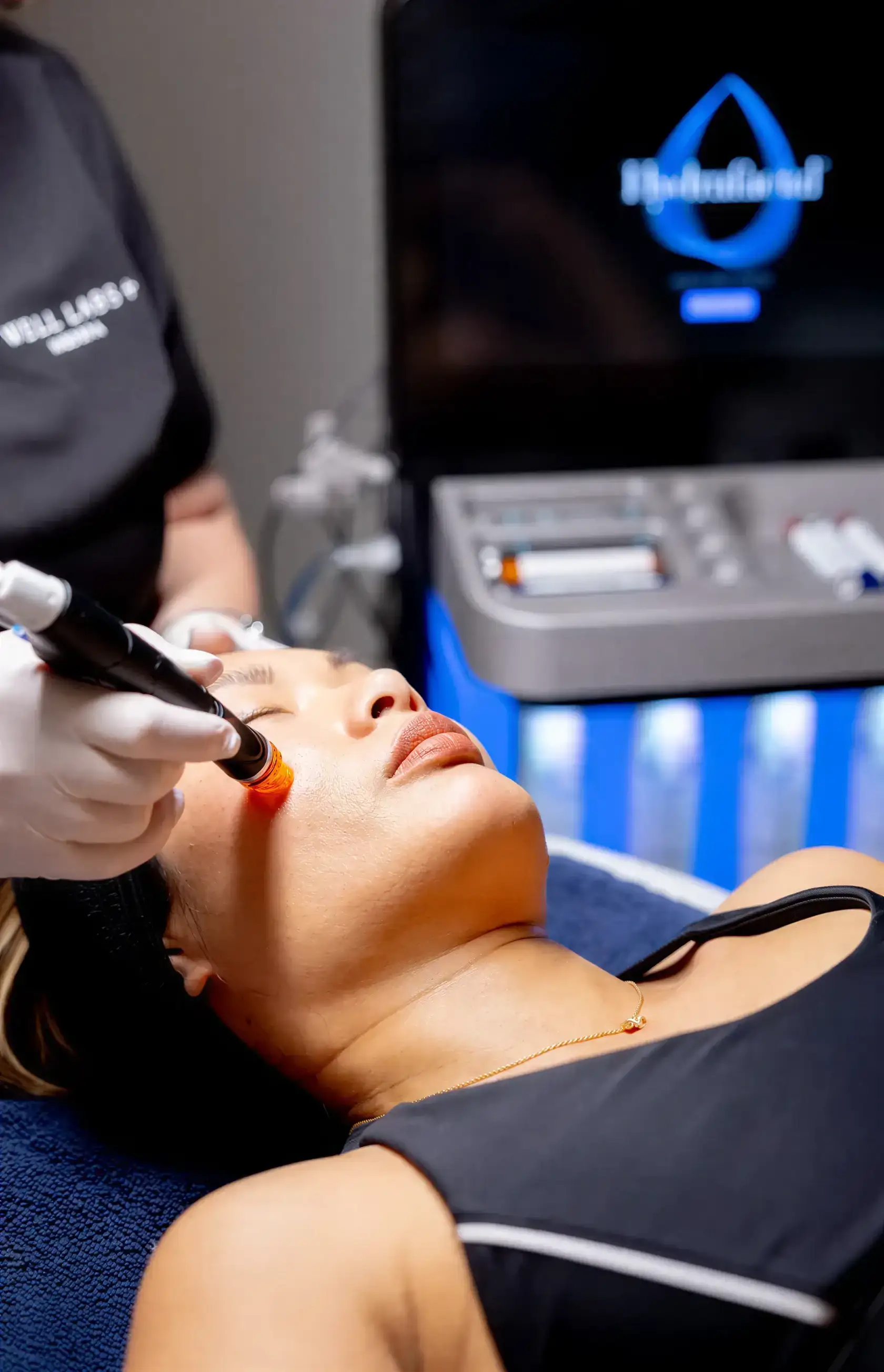 A provider treating a client's cheek with the HydraFacial wand during an in-office session
