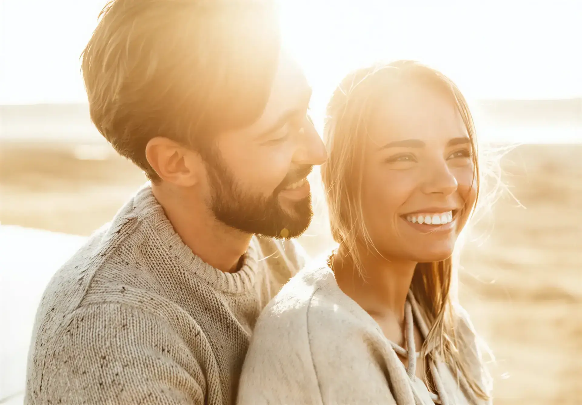 A couple smiling together in warm backlit sunlight