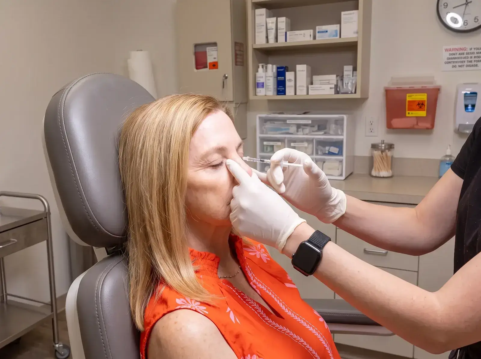 A gloved provider administering a Xeomin injection near a client's brow at Well Labs+ Dallas