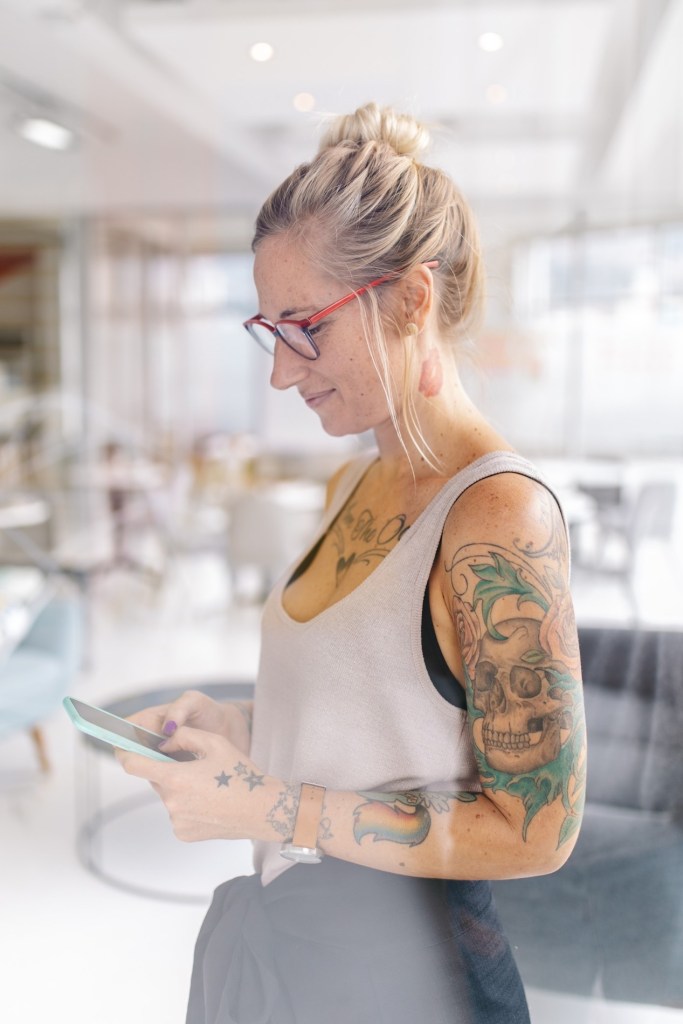 A client with a visible tattoo discussing removal options with a specialist at Spa in the City, Dallas.